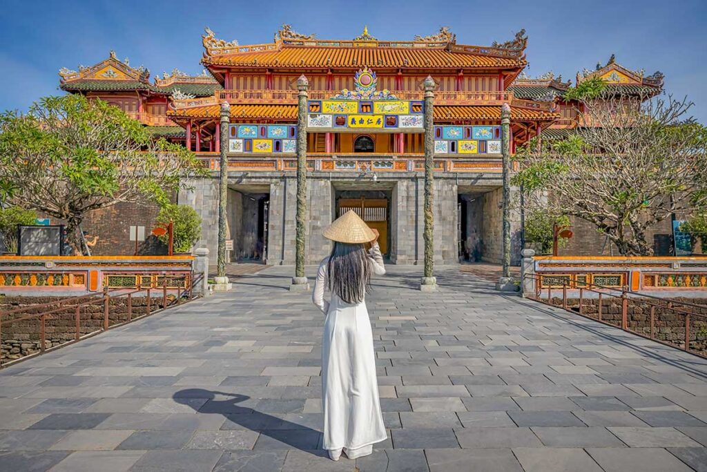 Hue tours – Local Vietnam | traveler in traditional Vietnamese ao dai exploring the Imperial City of Hue, Vietnam’s former royal capital