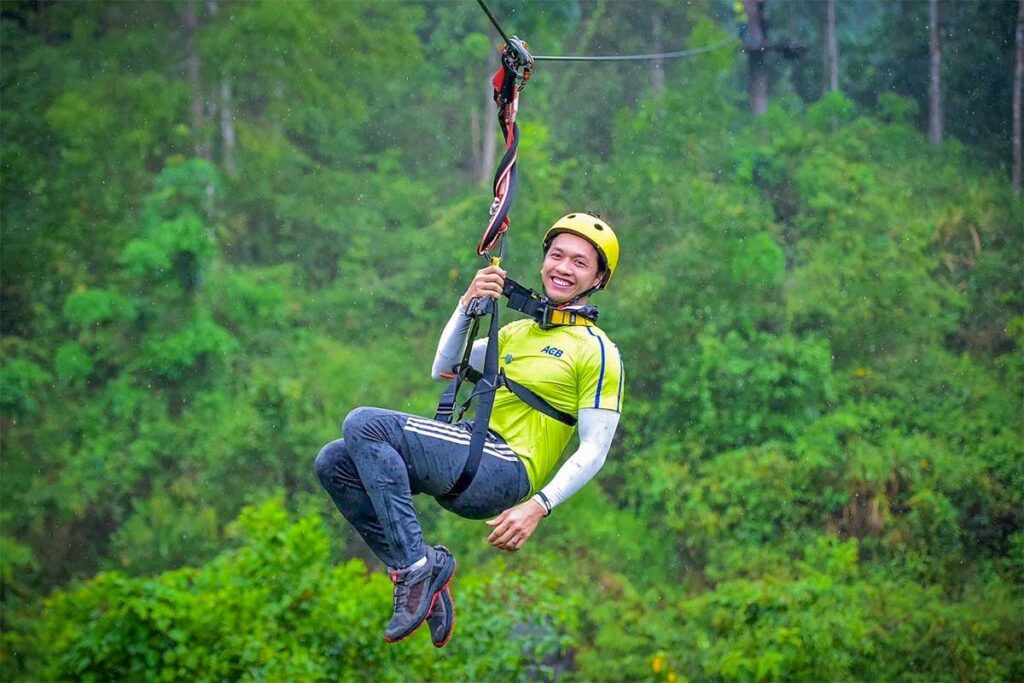 Traveler enjoying a thrilling jungle zipline ride at Kong Forest, located on the slopes of Hon Ba Nature Reserve near Nha Trang.