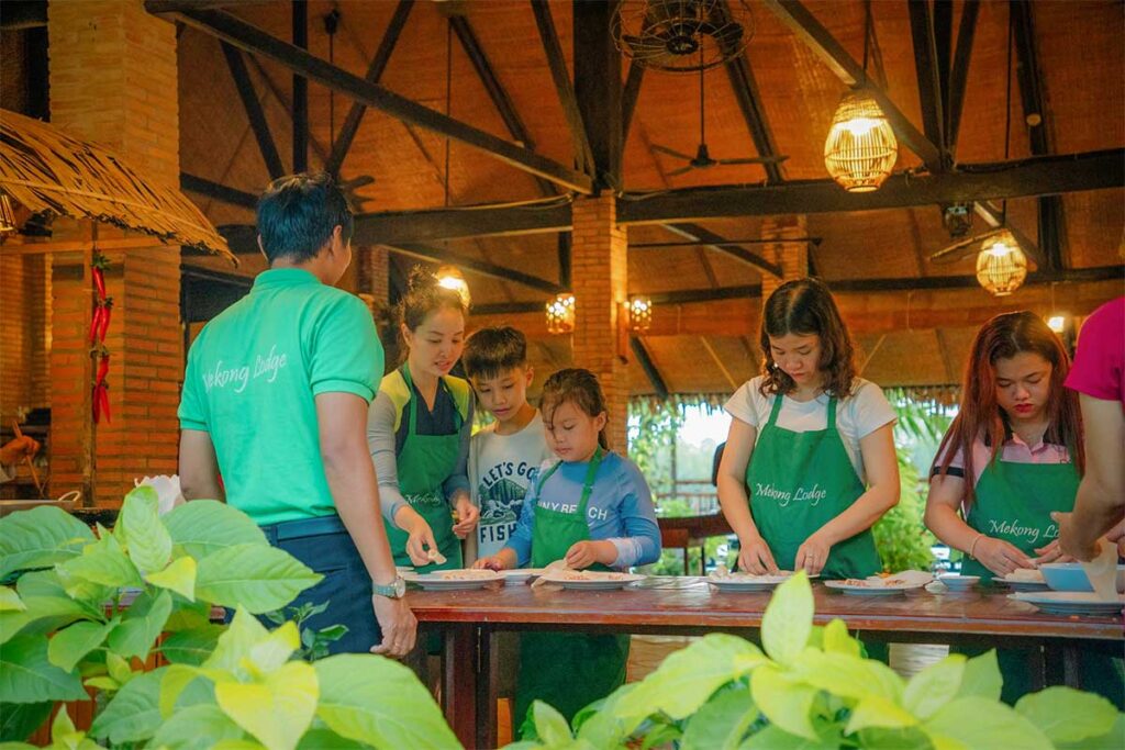 Children joining a Vietnamese cooking class at Mekong Lodge in the Mekong Delta, a fun hands-on activity for families with kids.