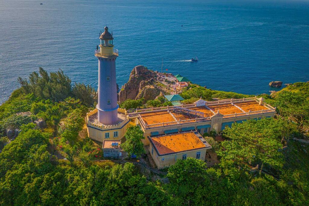 Mui Dien (Dai Lanh) Lighthouse in Phu Yen, Vietnam, surrounded by rocky cliffs and overlooking the East Sea.