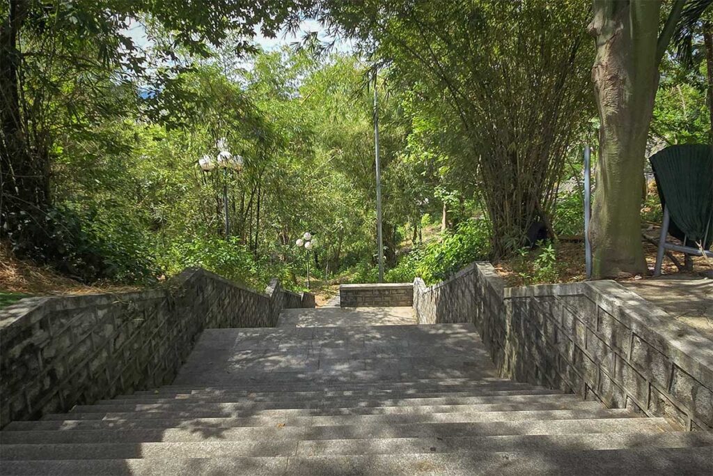 Stone staircase leading through shaded greenery up to Nhan Tower on Nhan Mountain in Tuy Hoa, Phu Yen