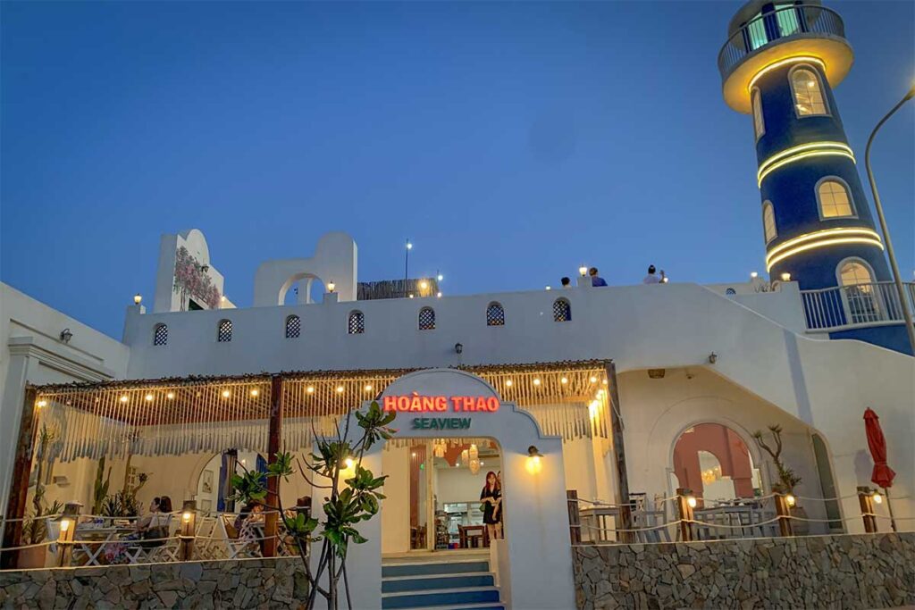Hoang Thao Seaview seafood restaurant with a lighthouse-style tower at dusk in Nhon Ly, Quy Nhon, a popular dinner stop near Eo Gio.