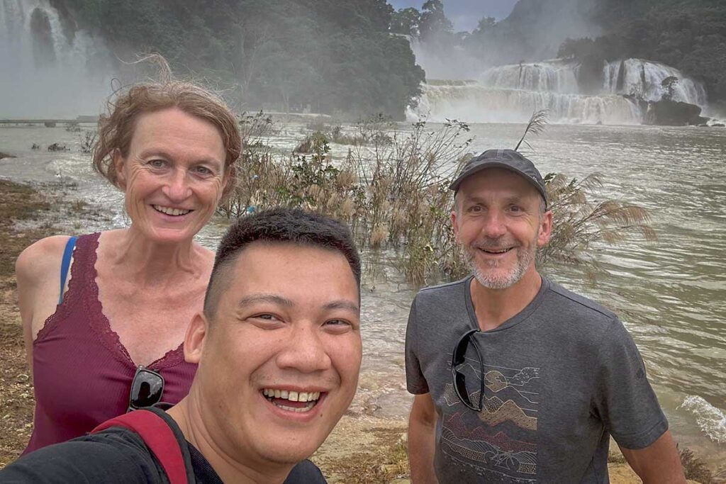 Local Vietnam guide sharing a private moment with travelers at Ban Gioc Waterfall — authentic, personalized tours connecting international visitors with Vietnam’s natural highlights.