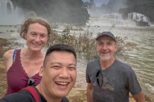 Local Vietnam guide sharing a private moment with travelers at Ban Gioc Waterfall — authentic, personalized tours connecting international visitors with Vietnam’s natural highlights.