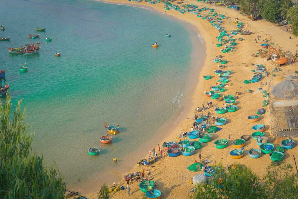 Quy Nhon tours – Local Vietnam | fishing boats and round basket boats along the sandy beach of Quy Nhon, Vietnam