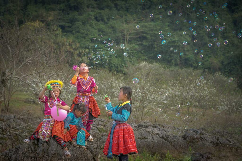 Son La tours – Local Vietnam | ethnic minority children in traditional colorful clothes playing and blowing bubbles in Son La, Vietnam