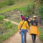 Travelers walking on a small mountain path during a local trekking experience in Ha Giang.