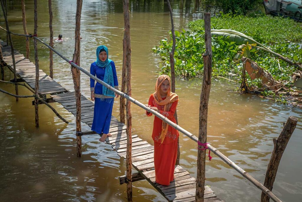 Chau Doc tours with Cham women crossing a wooden bridge over the river in An Giang