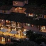 Night view of Ha Giang Aya Lodge by Local Vietnam with warm lights, balconies and mountain surroundings.