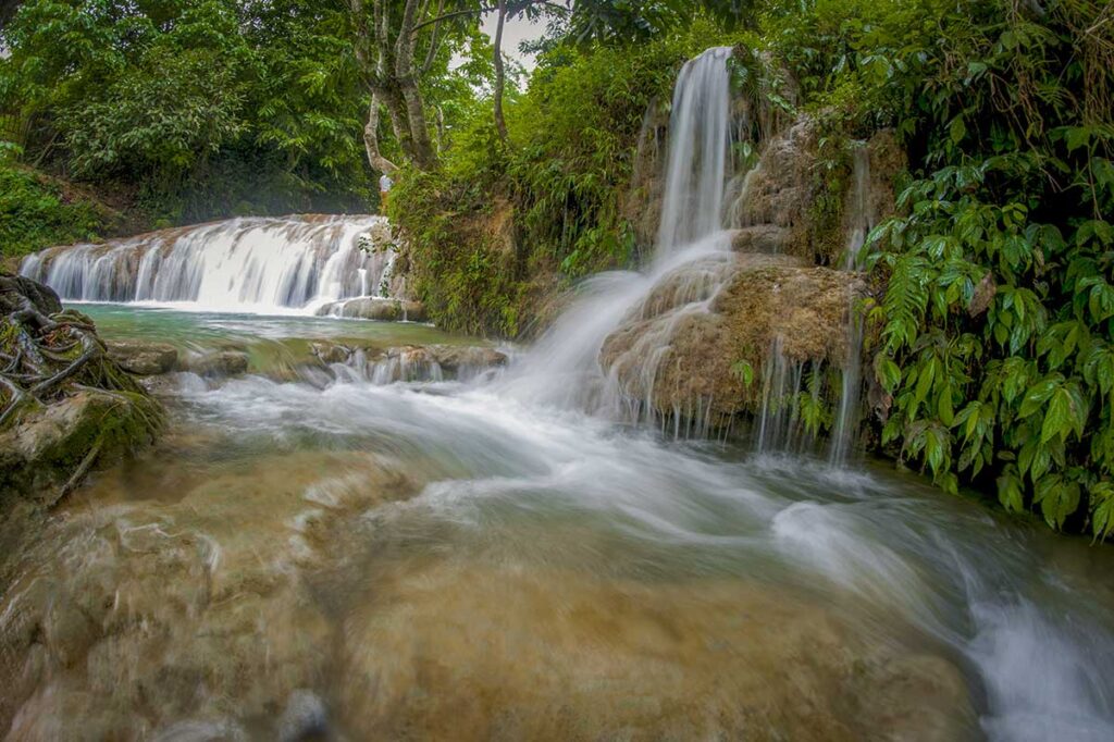 Hieu Waterfall tours with cascading limestone pools and clear turquoise water in Pu Luong
