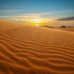 Mui Ne Sand Dunes tours with golden rippled sand at sunrise