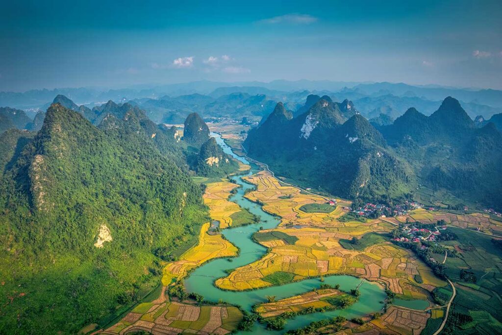 Aerial view of the turquoise river valley and limestone peaks of Cao Bang, a breathtaking highlight on many North Vietnam tours.