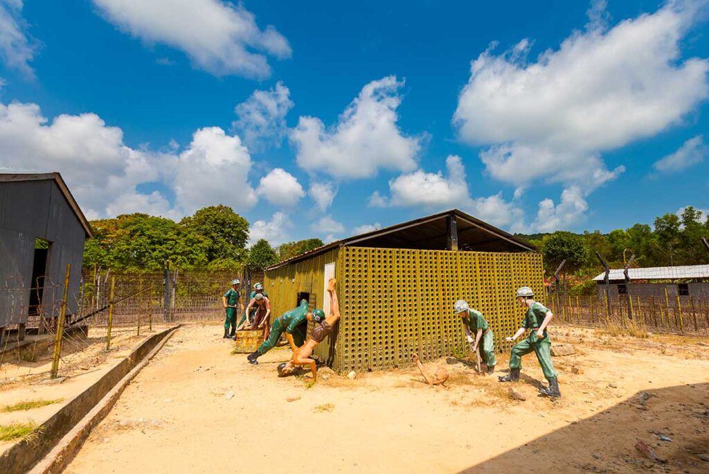 Wax figures of guards and prisoners depicting a torture scene outside the corrugated iron barracks at Phu Quoc Prison, Vietnam.