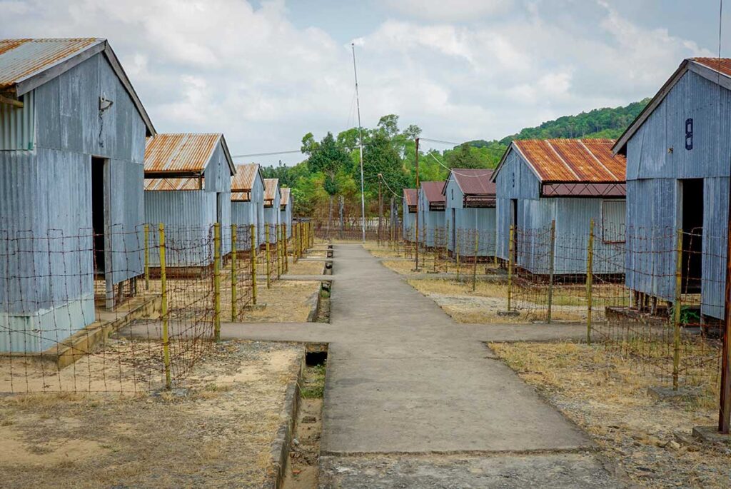 Phu Quoc Prison tours with rows of corrugated metal barracks and barbed-wire fences from the wartime camp