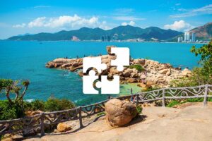 Private Nha Trang tour with a personalized itinerary, combining rocky coastal viewpoints, blue sea, and a scenic beachfront skyline.