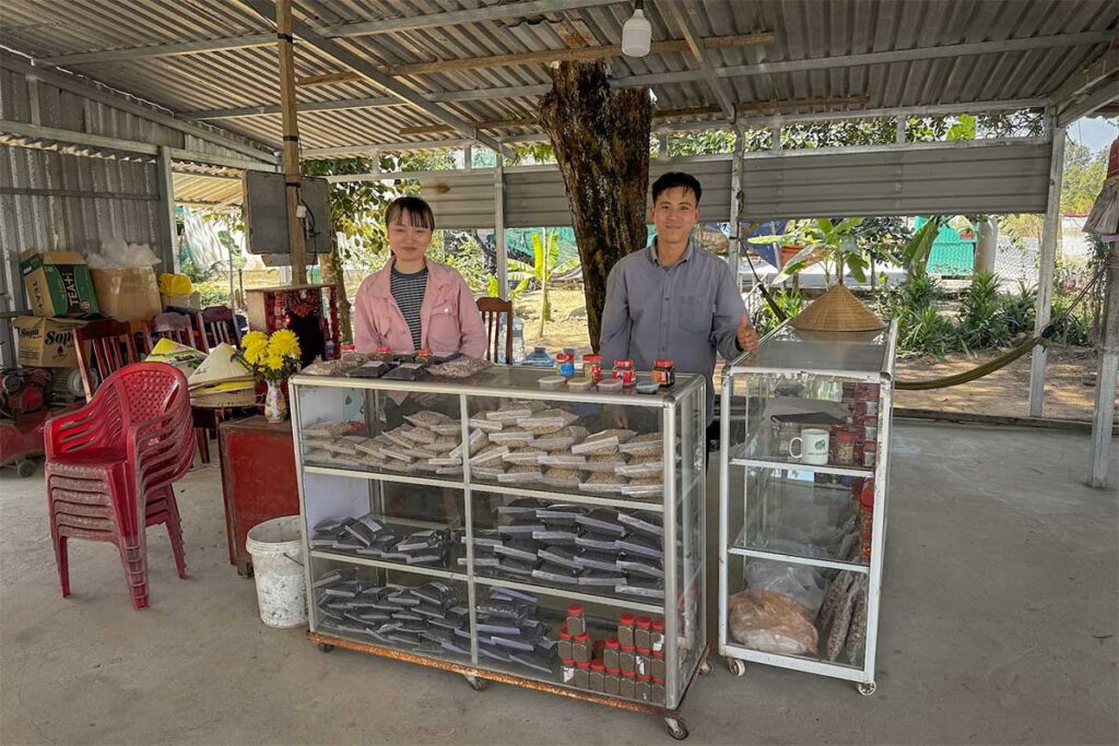 The family owners of Vuon Tieu Hai Duong standing behind their pepper and spice counter in Phu Quoc