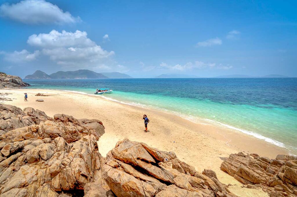 Crystal-clear water and quiet beach on Con Dao Island, ideal for snorkeling and relaxing boat excursions on a Southern Vietnam tour.
