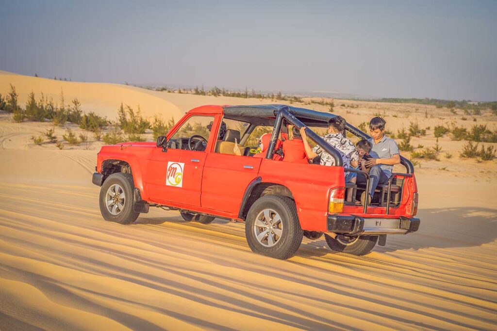 Travelers driving by jeep through the sand dunes near Mui Ne, a scenic coastal adventure included in many South Vietnam tours.