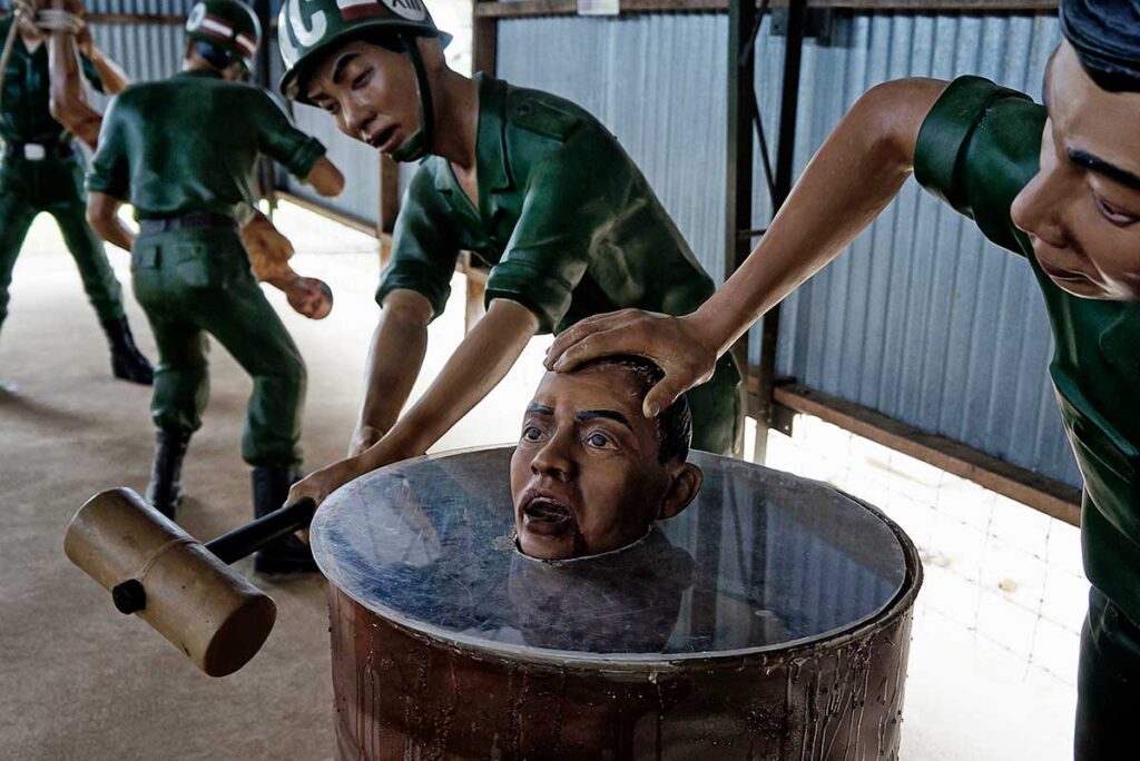 Wax figures depicting a water submersion torture scene at Phu Quoc Prison, showing guards forcing a prisoner's head into a barrel of water during the Vietnam War period.