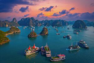 Boats sailing between limestone islands in Halong Bay at sunset — a highlight of our 2-week Vietnam itinerary covering Hanoi, Ninh Binh, and Hoi An in 14 days.