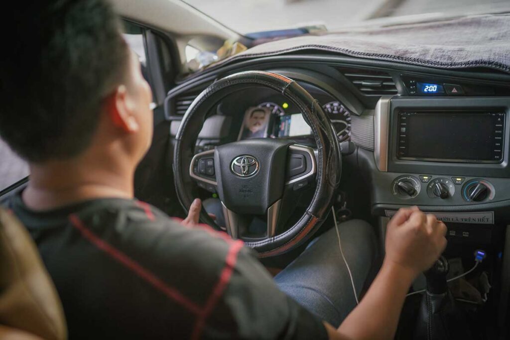 Professional driver operating a Toyota during a private trip — showing comfort and reliability of Vietnam car rental with driver services.