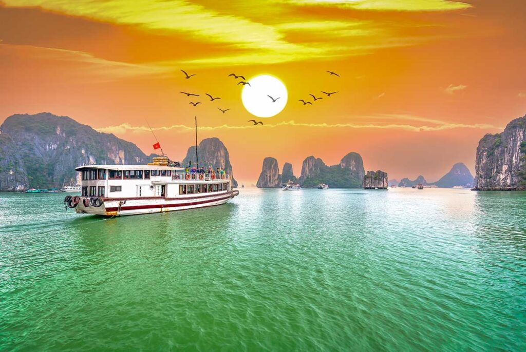 Cruise boats gliding among limestone karsts in Halong Bay, one of the most iconic experiences included in nearly all Vietnam package tours.