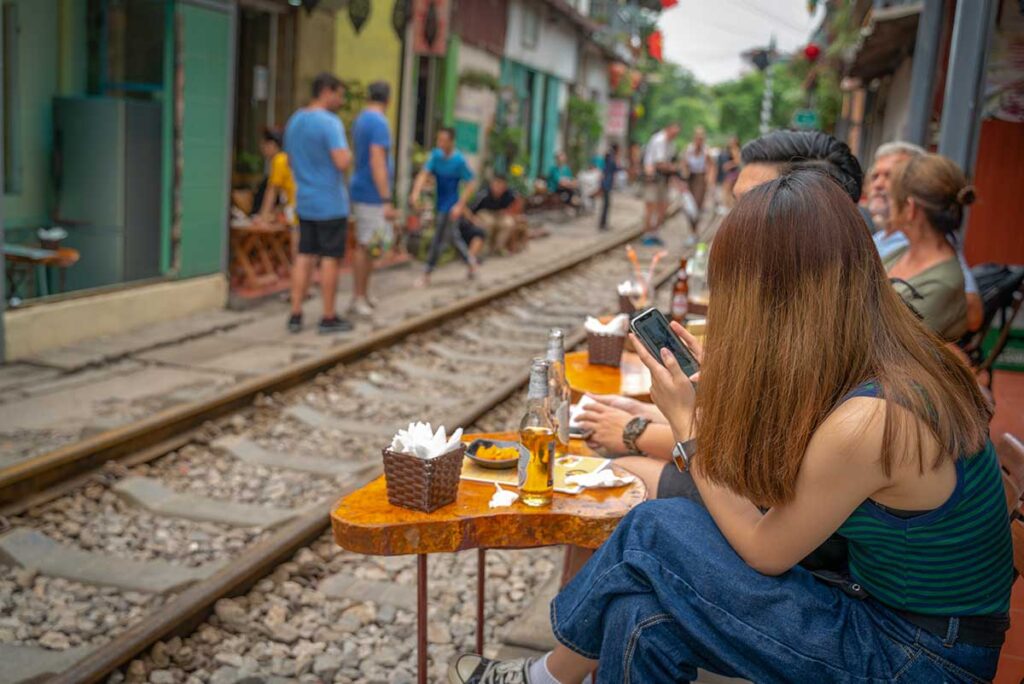 Local life in Hanoi’s Old Quarter with colorful colonial buildings and street cafés, offering a lively introduction to Vietnam package tours.