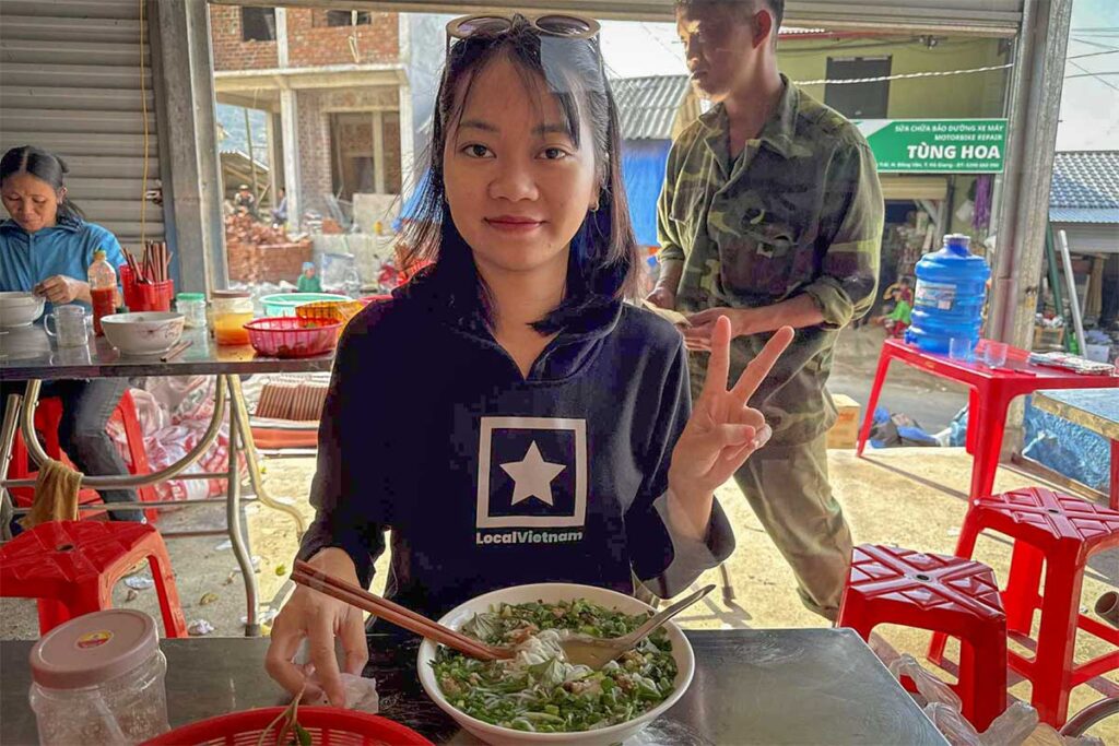 Local Vietnam guide enjoying traditional Vietnamese noodles at a local eatery — authentic travel experiences with real local guides.