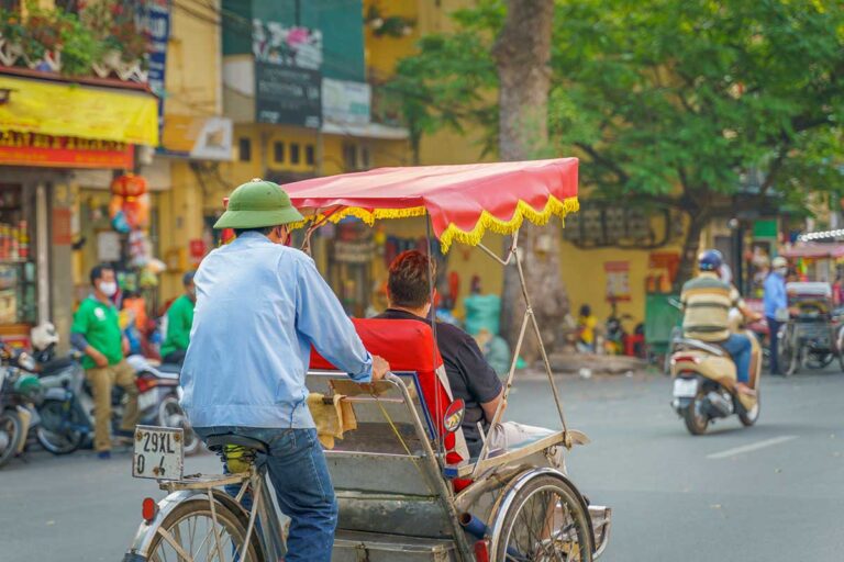 Cyclo ride through the busy streets of Hanoi’s Old Quarter, a classic way to explore the capital during Vietnam tours.