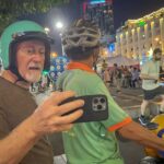 Guest riding as a passenger on a Hanoi motorbike tour with Local Vietnam at night, captured in the Old Quarter area and showing authentic evening street life, crowds, and real city conditions.