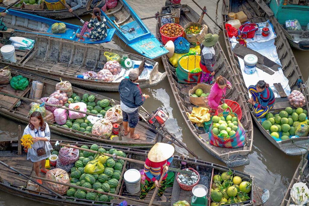 Mekong Delta floating market tours visiting busy river markets with wooden boats selling fruit and local produce