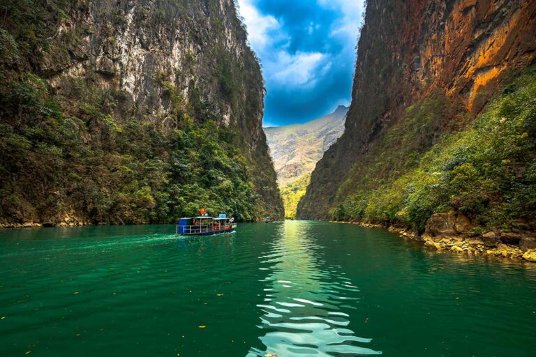 Boat trip on the Nho Que River in Ha Giang, cruising through the dramatic canyon below Ma Pi Leng Pass during a Ha Giang Loop tour