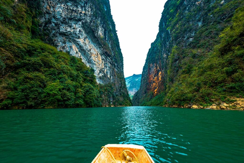 View from a boat on the Nho Que River beneath Ma Pi Leng Pass, one of the most scenic highlights of the Ha Giang Loop