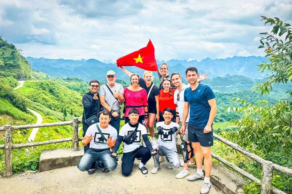 Dutch travelers on a Ha Giang Loop Easy Rider group tour with Local Vietnam, standing with local guides at a mountain viewpoint during a guided motorbike tour in Ha Giang