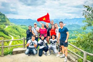 Dutch travelers on a Ha Giang Loop Easy Rider group tour with Local Vietnam, standing with local guides at a mountain viewpoint during a guided motorbike tour in Ha Giang