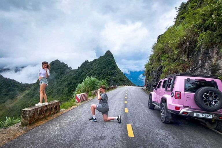 Ha Giang Loop jeep tour with Local Vietnam, showing guests stopping on a mountain road for photos while exploring the loop by off-road vehicle