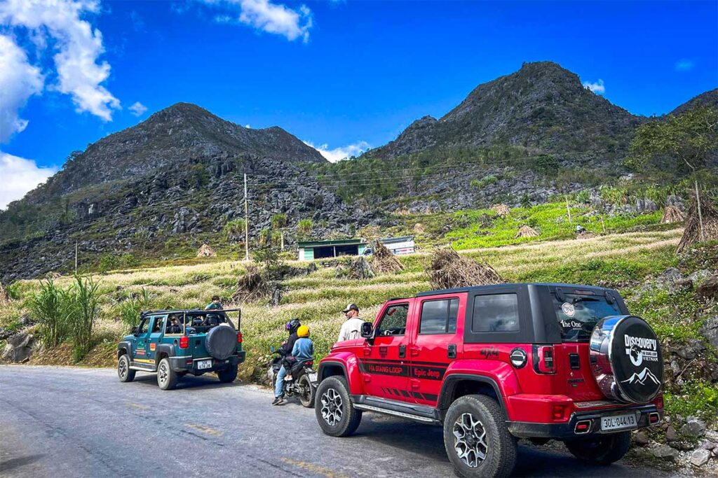 Family-friendly Ha Giang Loop jeep tour with Local Vietnam, showing parents and a child enjoying views from the front of the jeep at a scenic stop