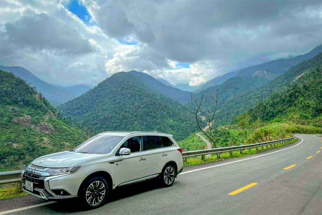 Car driving through Khanh Le Pass with panoramic mountain views, showing a comfortable alternative to motorbike travel on this scenic route