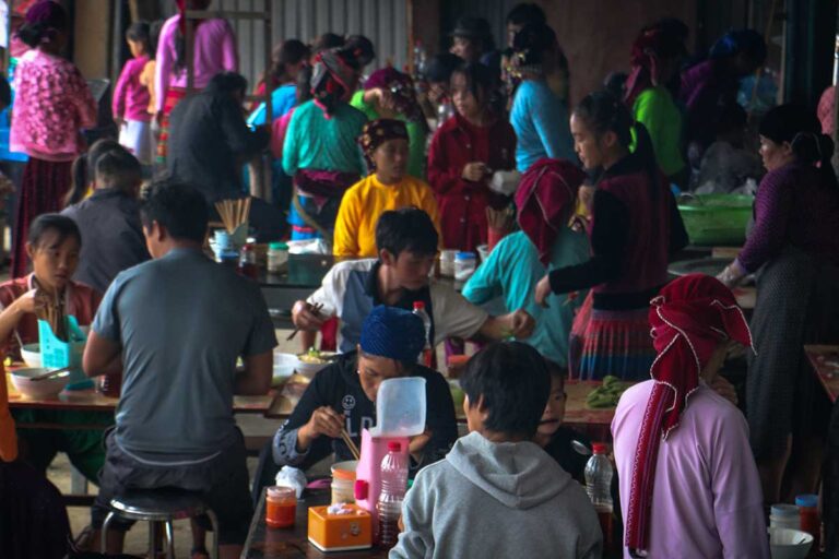 Local ethnic market in Sung Trai, Ha Giang, with villagers gathering to eat, socialize, and trade during the Ha Giang Loop
