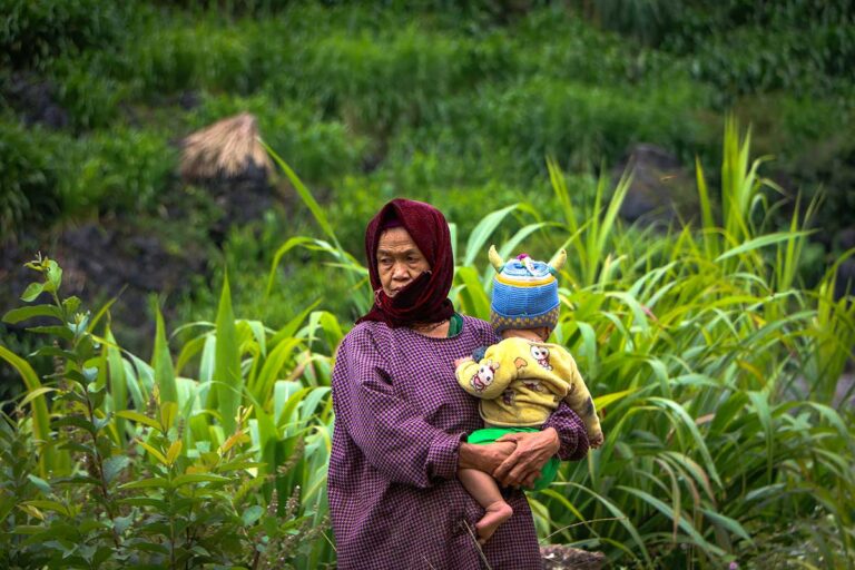 Local ethnic woman with child during a village trek near Ha Giang Aya Lodge, showing everyday life in the mountains of Ha Giang