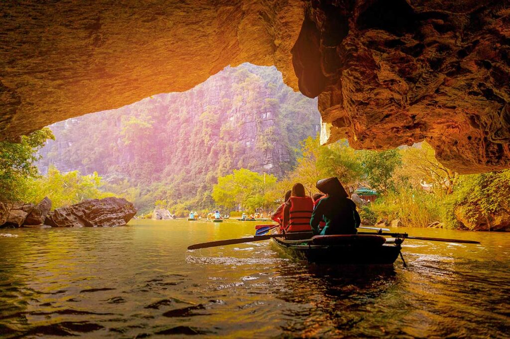 Vietnam slow travel holidays featuring peaceful boat rides through rivers and limestone landscapes, showcasing calm and scenic travel experiences in Vietnam