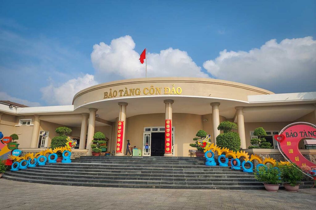 Front entrance of Con Dao Museum with Vietnamese flag and main building facade located in Con Son town.