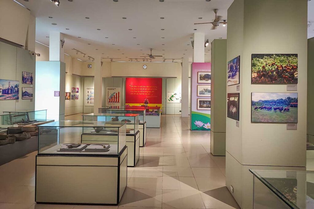 Overview of exhibition hall inside Con Dao Museum with display cases, historical photos and information panels about the island’s past and development.