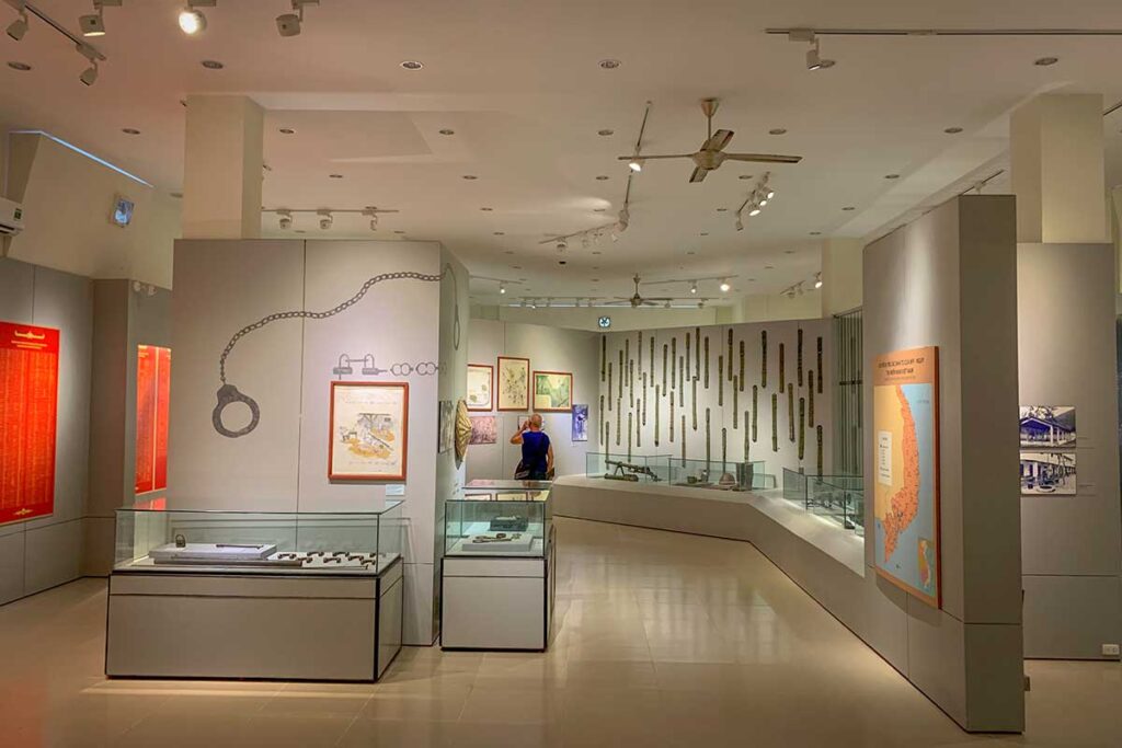 Exhibit inside Con Dao Museum showing shackles and prison restraints along the wall, highlighting the harsh conditions prisoners endured.