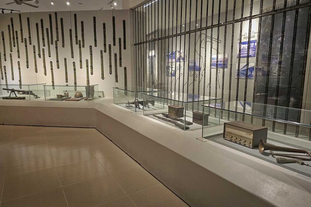 Exhibition area in Con Dao Museum showing weapons, prison bars and historical objects related to the Vietnam War period.