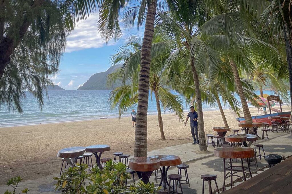 Palm-lined beach area at Tan Son Nhat Con Dao Resort with sandy shore, sun loungers, and relaxed tropical setting