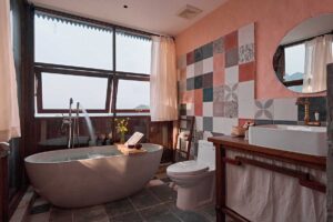 Bathroom of a bungalow at Ha Giang Aya Lodge with freestanding bathtub and mountain views in Ha Giang.