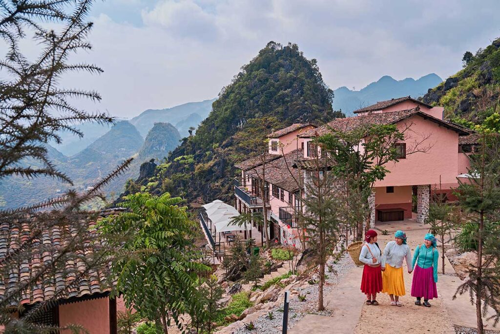 Hmong staff from Ha Giang Aya Lodge walking through the village near the lodge in the mountains of Ha Giang.