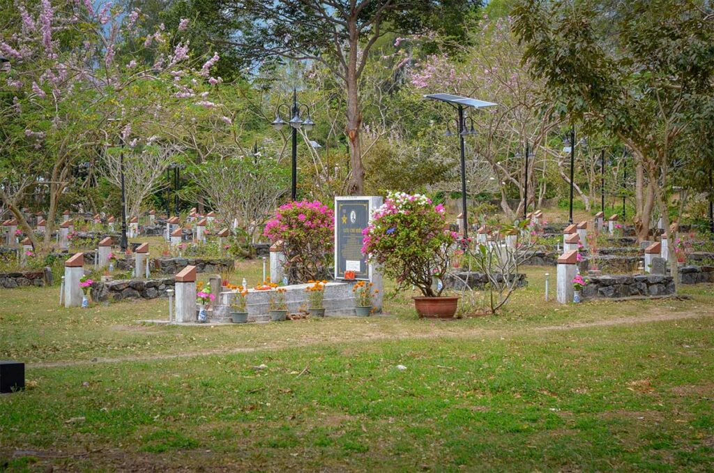 Rows of simple and unmarked graves under trees at Hang Duong Cemetery, reflecting the history of prisoners who died on Con Dao.