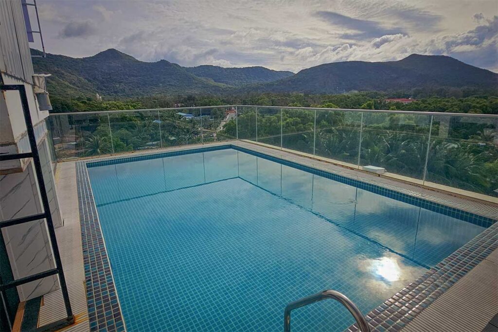 Rooftop swimming pool at Maya Hotel 2 Con Dao overlooking green hills and surrounding town